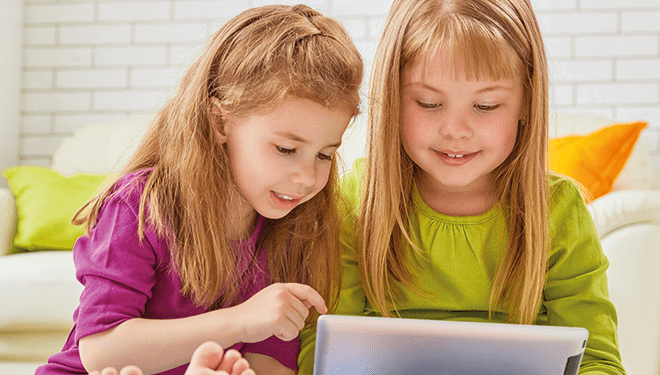 Zwei Mädchen schauen auf ein Tablet